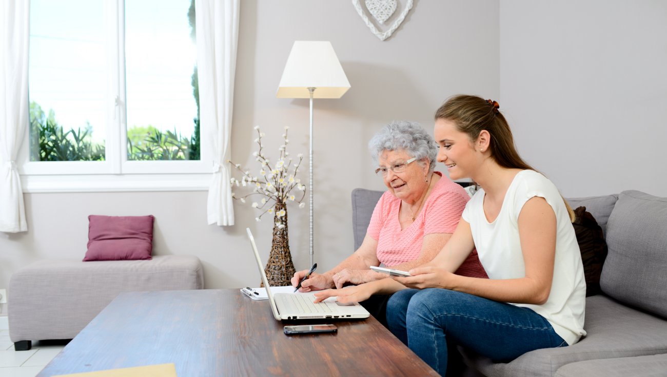 Woman helping elderly mom on laptop